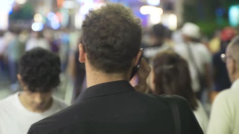 joven hablando por teléfono en la calle nocturna.