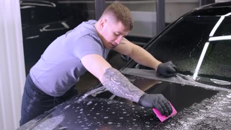 man covering car with vinyl polyurethane tape. films for the car. sticker protective film on the car