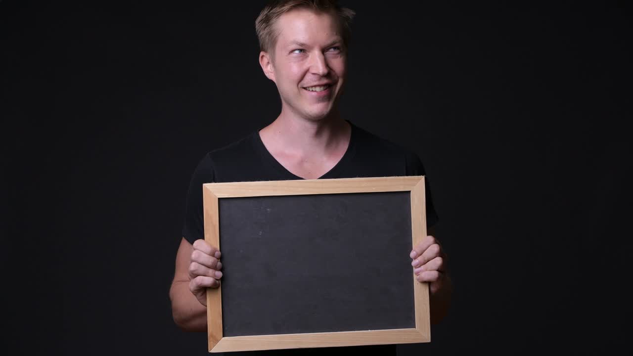 Man Holding Empty Blackboard While Thinking