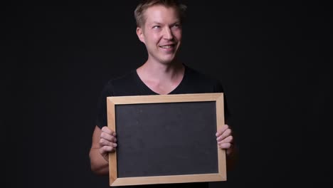 man holding empty blackboard while thinking