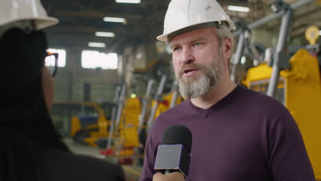 senior factory engineer giving interview to tv journalist