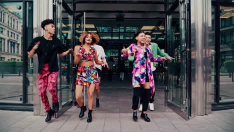 un grupo de elegantes bailarines gen z está realizando una rutina de baile animada y sincronizada frente a un edificio de vidrio moderno, mostrando su energía y entusiasmo