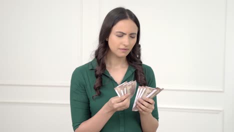 Sad-Indian-woman-counting-money