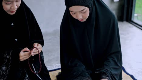 two young muslim woman praying in prayer room