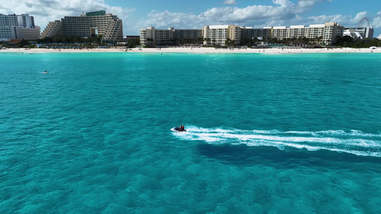 vista aérea rastreando una moto de agua frente a la zona hotelera, en el soleado cancún, méxico