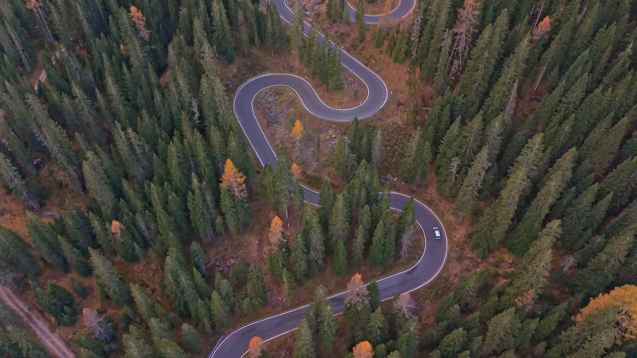 Scenic aerial of Snake Road in vibrant fall forest, Dolomites, Italy
