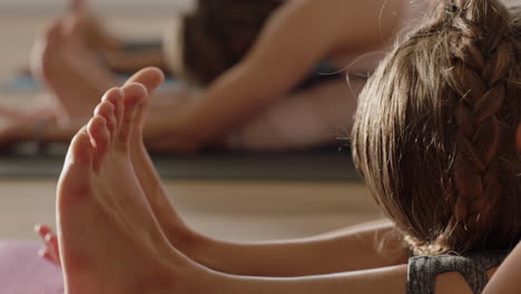 Un-Grupo-Cercano-De-Mujeres-En-Clase-De-Yoga-Practicando-La-Postura-De-Curvatura-Hacia-Adelante-De-La-Cabeza-A-La-Rodilla-Entrenando-Un-Estilo-De-Vida-Saludable-Haciendo-Ejercicio-Disfrutando-De-La-Meditación-En-El-Gimnasio.