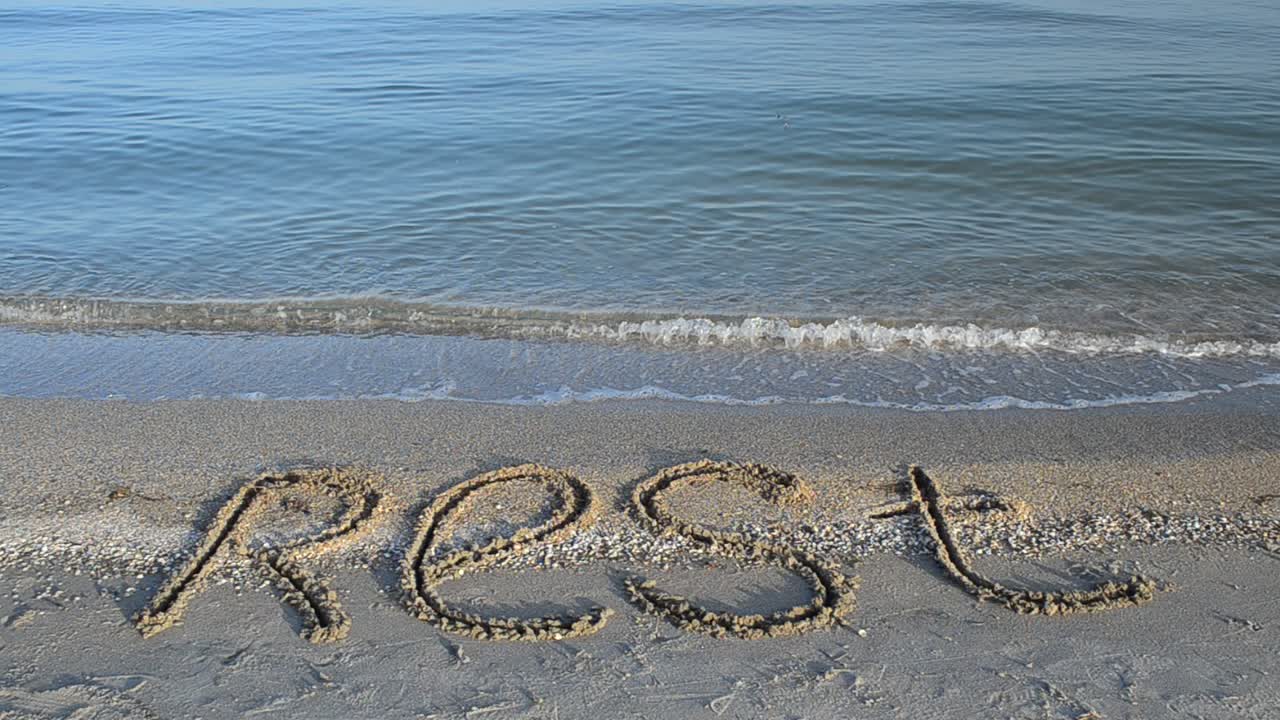 Inscription rest on sand, the beach. Inscription on sand, the beach