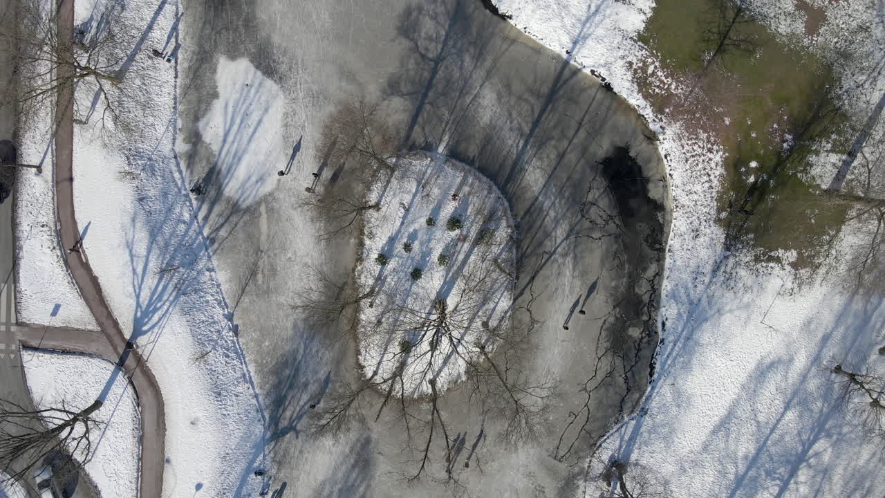 съемка сверху вниз людей, катающихся на коньках на замерзшем пруду в нидерландах