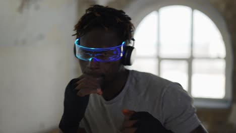 young male boxer practicing shadow boxing in light sport studio, close up