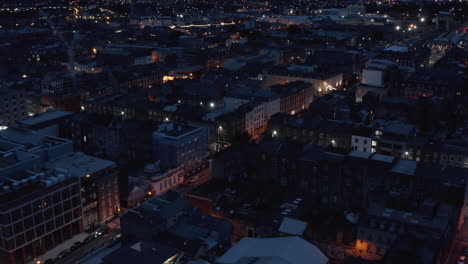 Ascending-footage-of-evening-city.-Blocks-of-buildings-in-urban-district.-Night-scene.-Limerick,-Ireland