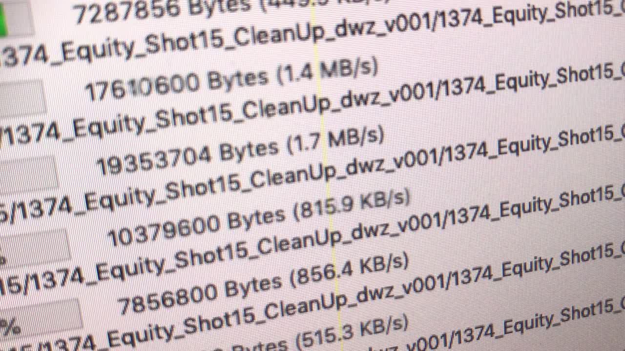 handheld super close shot of monitor showing growing upload bars, file names and percentages of a ftp program in German language