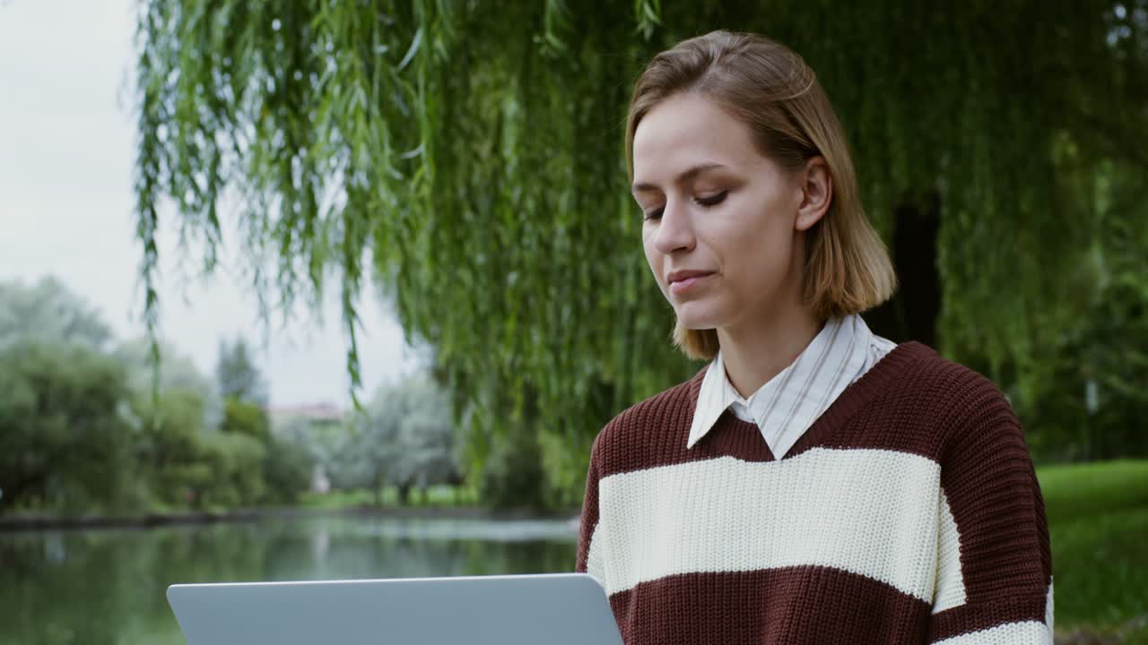 Woman working on a laptop in a park