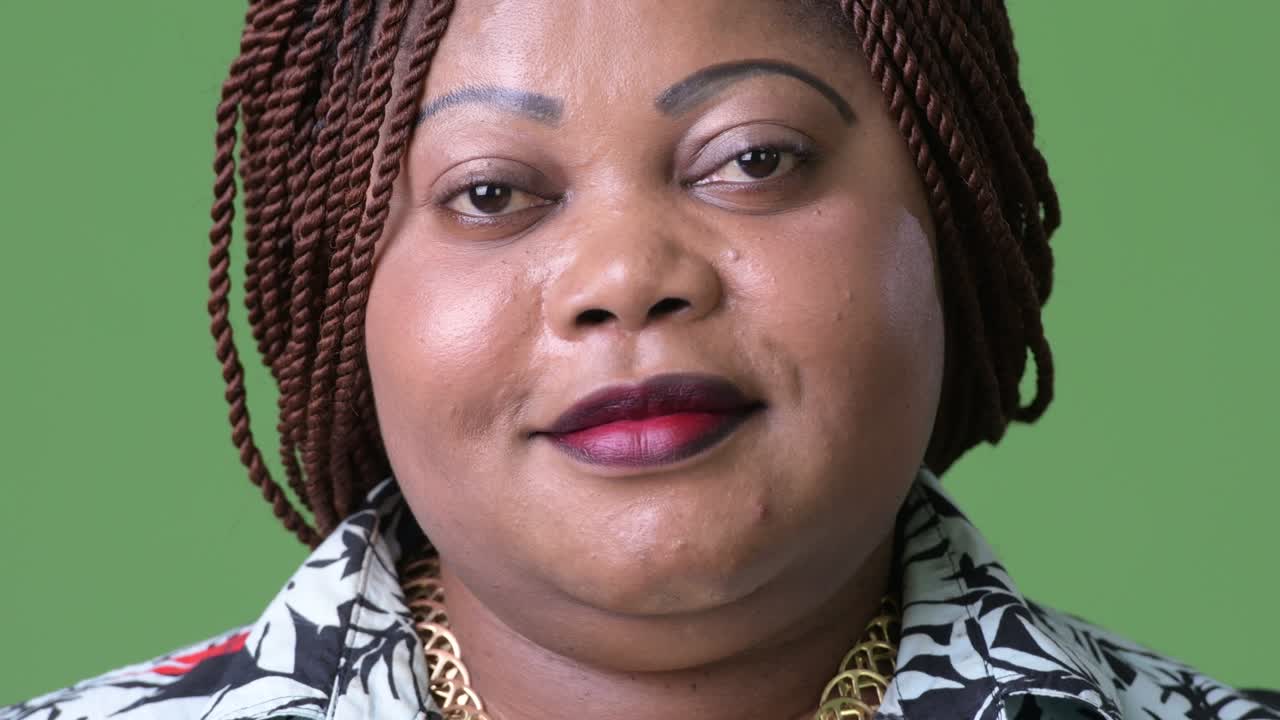 mujer africana hermosa con sobrepeso contra un fondo verde