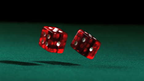 red dice falling and bouncing on green table