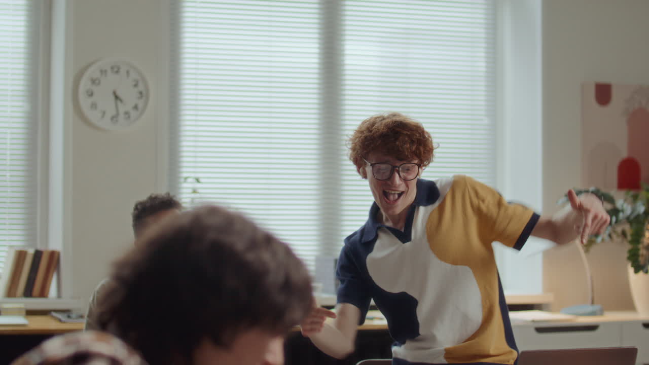 Excited Man Dancing and Celebrating Achievement with Team Support in Office