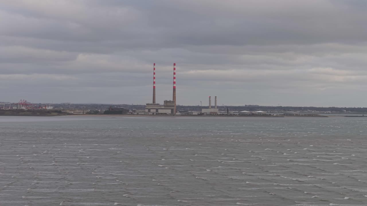 Poolbeg Generating Station on a stormy day with rough waters and a moody atmosphere