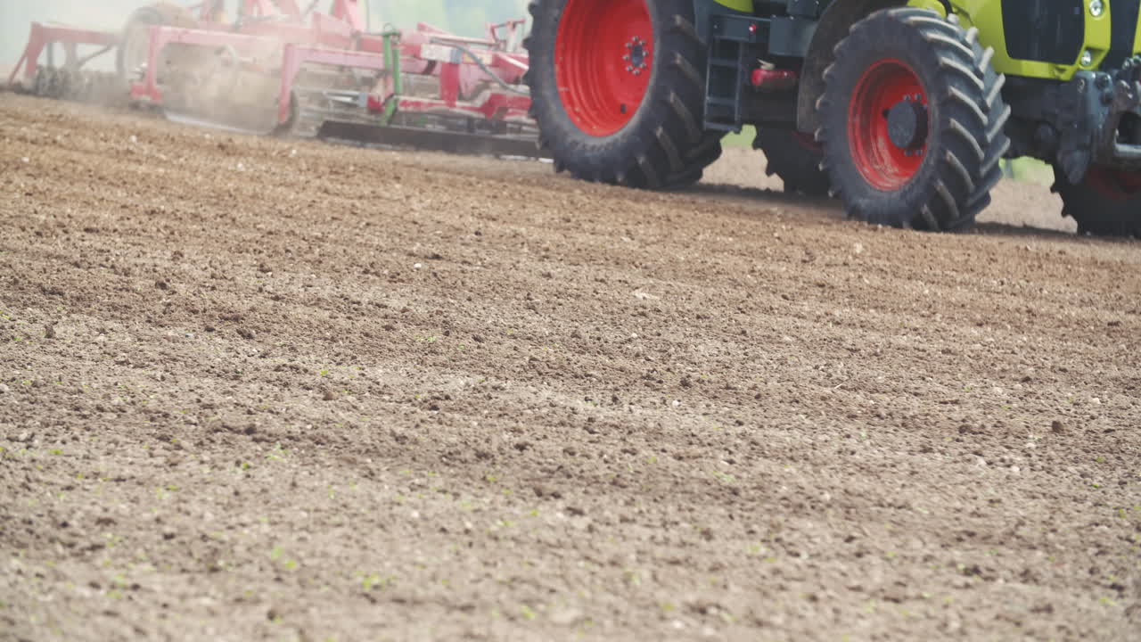 Trattore agricolo che ara un campo di terra marrone