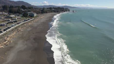 Aerial-View-Of-White-Foamy-Waves-Splashing-On-Sandy-Shore-Of-Beach-In-Brookings,-Oregon---drone-shot