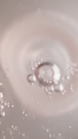 clear water with oxygen bubbles oscillates in plastic bottle with white nipple. refreshing drink in transparent container with measuring divisions macro