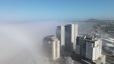 capa de niebla que llega a la ciudad costera desde el océano en bloubergstrand, ciudad del cabo