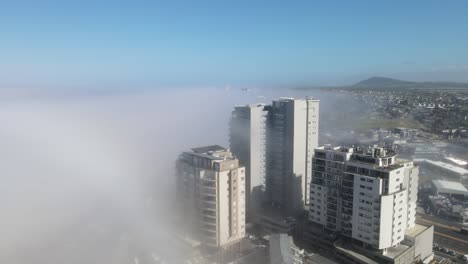 layer of fog coming in to the coastal city from the ocean in bloubergstrand, cape town