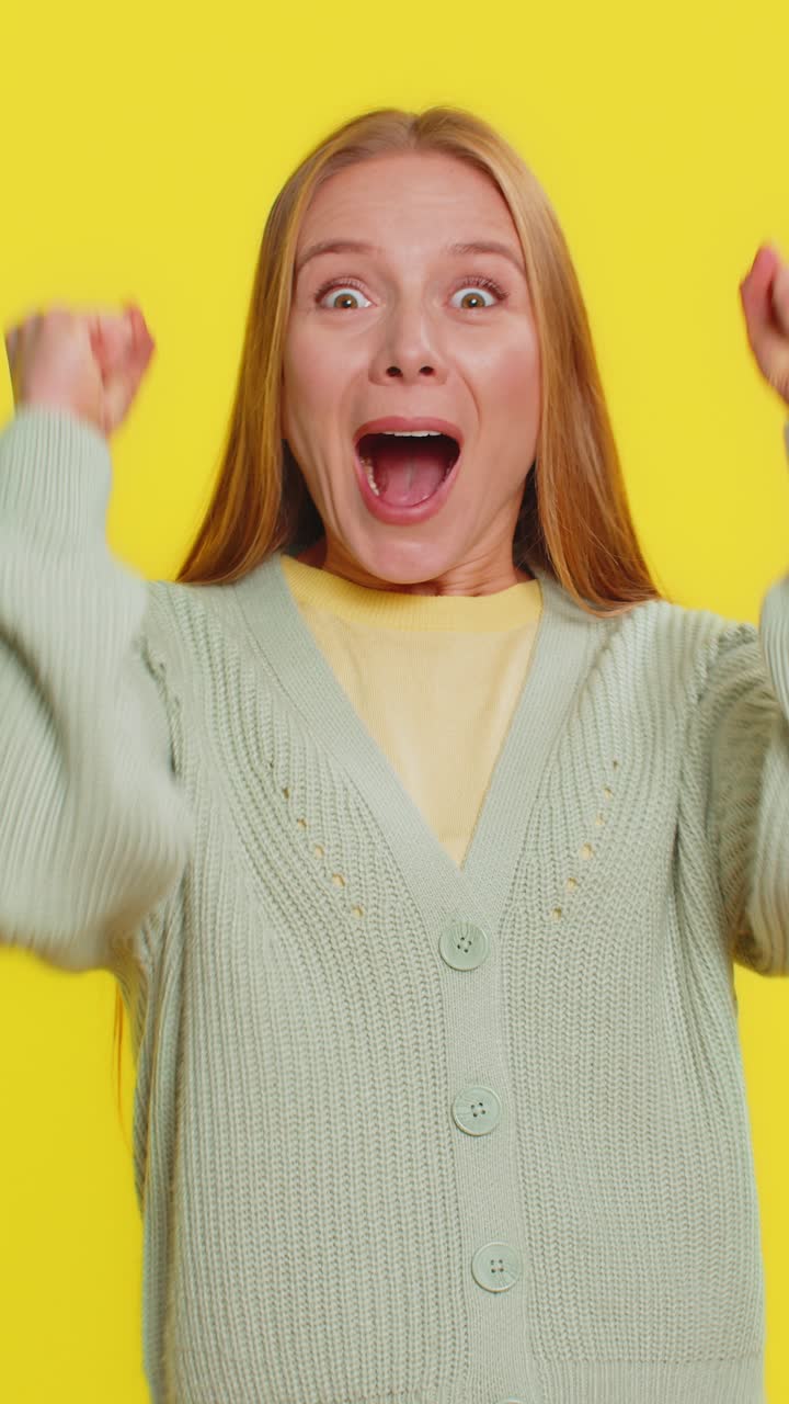 Donna matura felice che celebra il successo, la vittoria alla lotteria, il raggiungimento di un obiettivo, una buona notizia