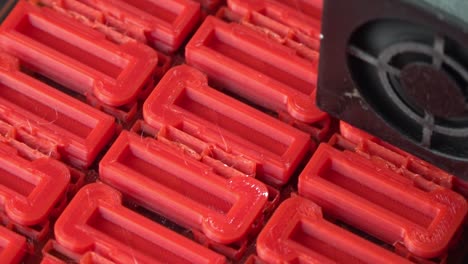 red pieces being printed on a 3d printer