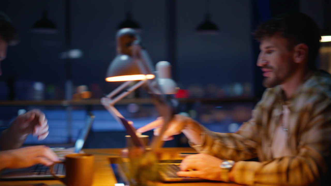 Talking manager typing computer at evening closeup. Night workers communicating