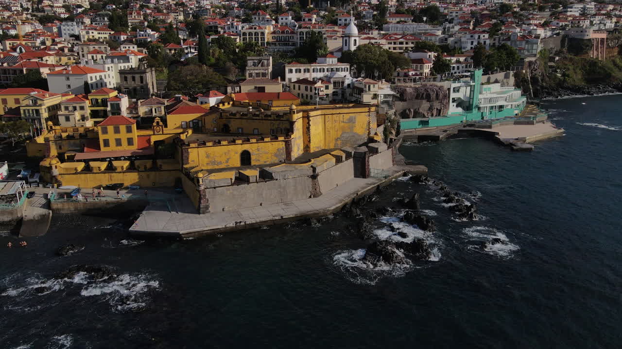toma aerea en un circulo del fuerte de madeira en la ciudad de funcal y donde se pueden ver las casas y edificios de la costa
