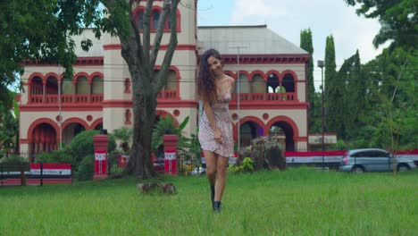 young curly hair girl enjoy playing in an open field in a mini dress and boots with a castle in the background