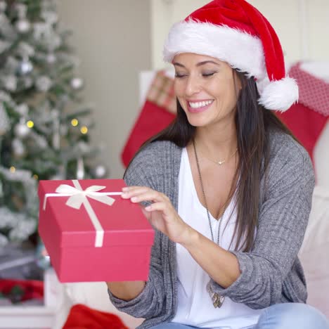 Excited-young-woman-opening-a-Christmas-gift