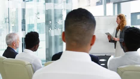 businesswomen discussing on white board with coworkers