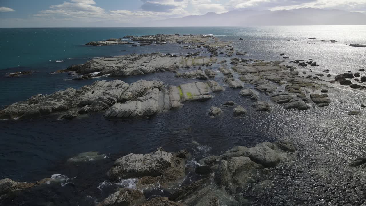 volando sobre uno de los arrecifes rocosos en kaikoura, nueva zelanda, un fantástico lugar de buceo para turistas