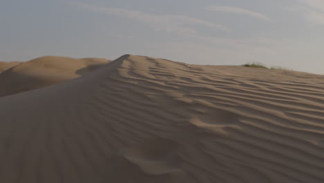 wind blows sand over desert dunes. timelapse