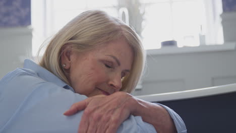 menopausal mature woman suffering with incontinence sitting on bathroom floor at home