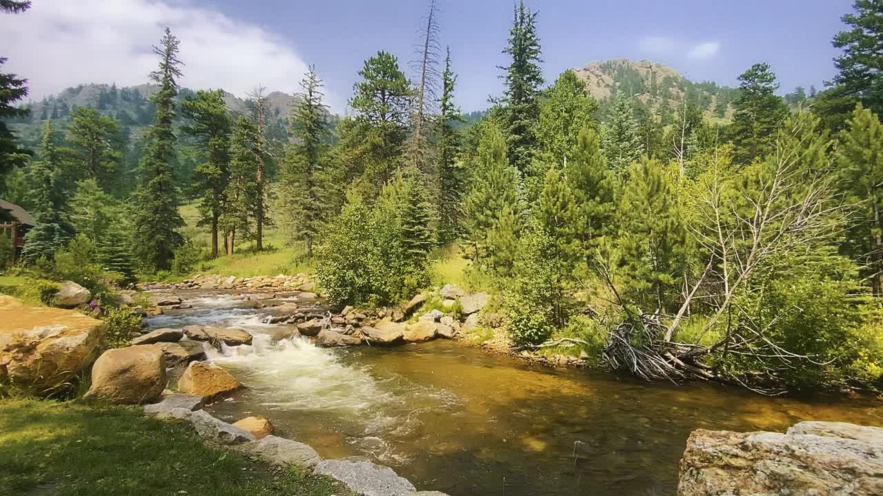Fast moving stream of clear, clean water flows through rocky stones, down a mountain river