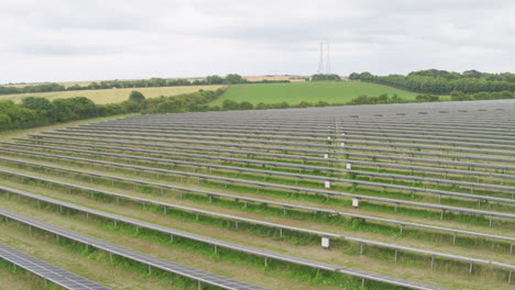 Reverse-angle-aerial-of-solar-panels,-vast-rows-of-photovoltaic-sheets-on-field