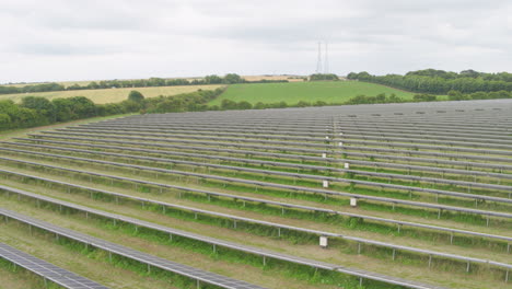 reverse angle aerial of solar panels, vast rows of photovoltaic sheets on field