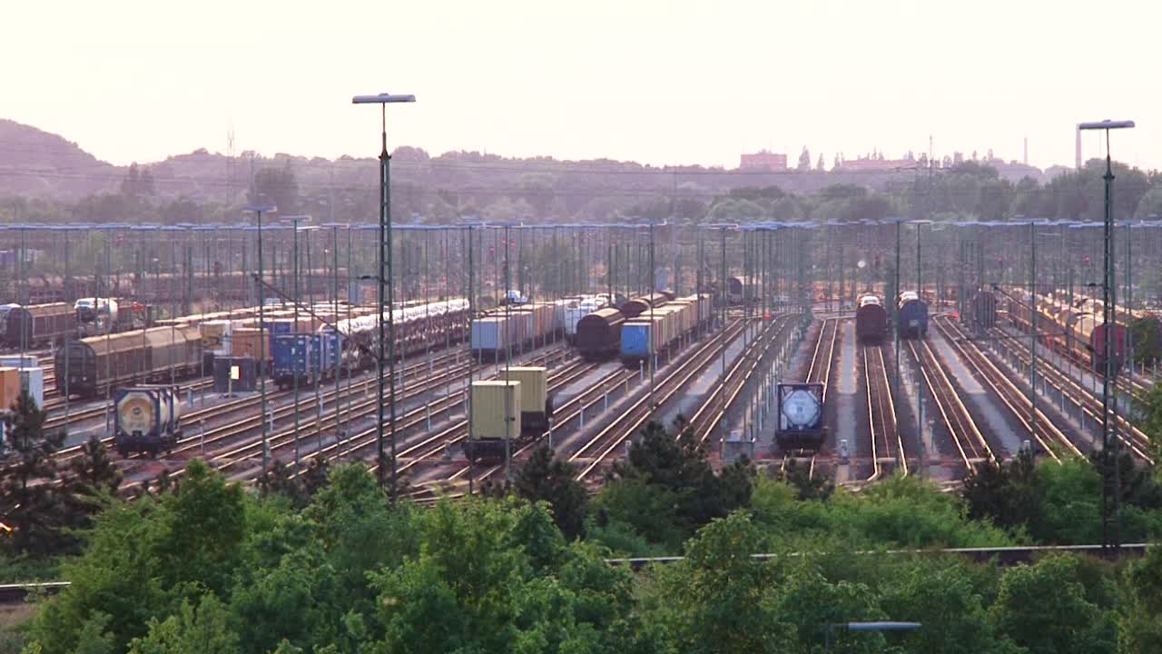 Railway yard with many tracks under pink evening sky, serene and vast