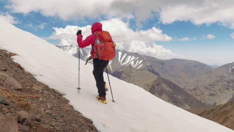 alpinist girl in crampons ascending the mountain in high atlas, morocco