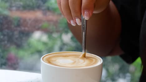 el café se agita a mano en una taza.