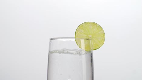 un vaso de agua con una rodaja de limón