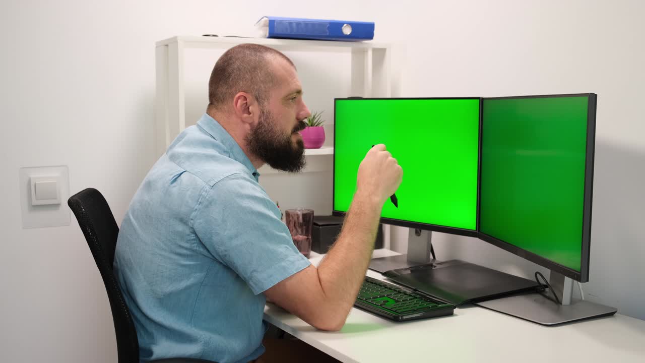 Business man at home. employee tell on video conference or video calling about new project pointing on two green screens or monitors.
