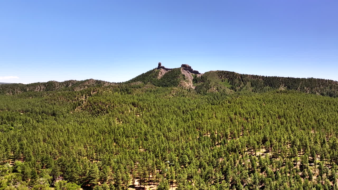 70 mm:n elokuvamainen ilmakuva dronella Chimney Rockista lähellä Owl Creek Passia Uncompahgren kansallismetsässä, lähellä Pagosa Springsiä, Colorado, kehystettynä karulla alppimaastolla ja rosoisilla huipuilla