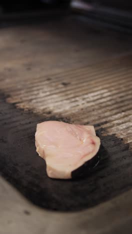 chef putting a slice of swordfish on top of the grill