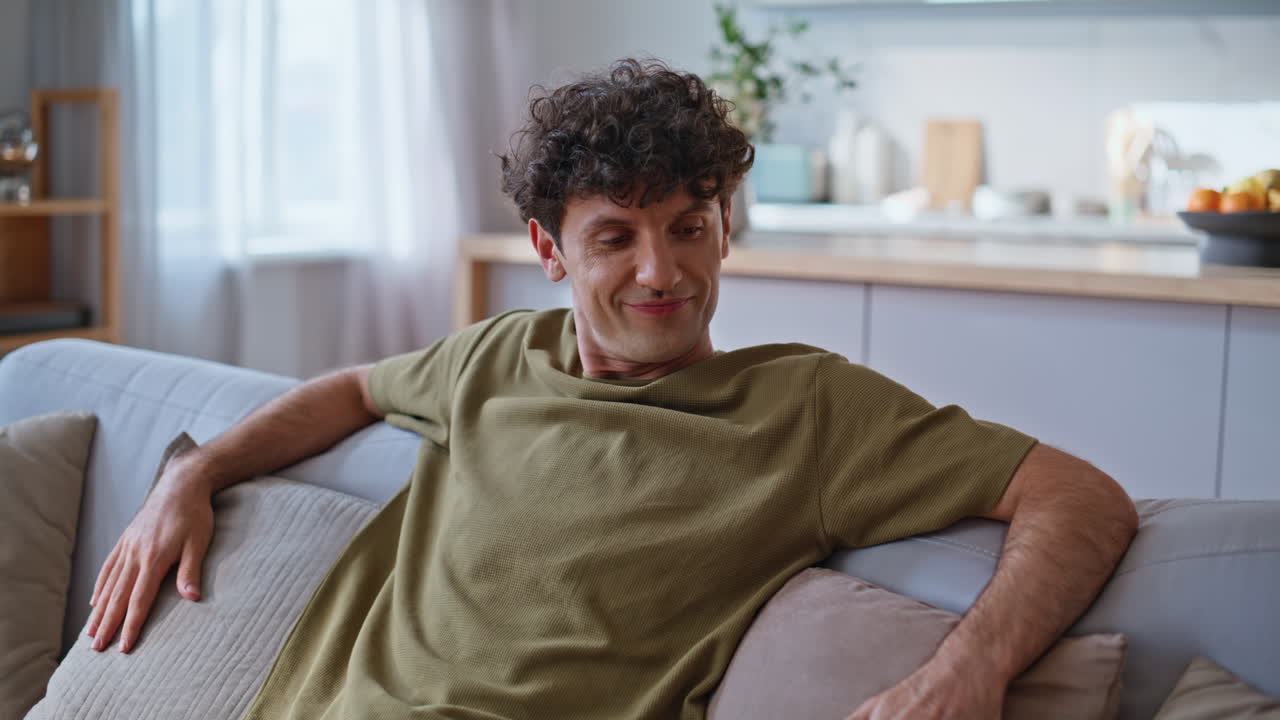 Chilling guy sitting sofa feeling comfortable home closeup. Man enjoying weekend