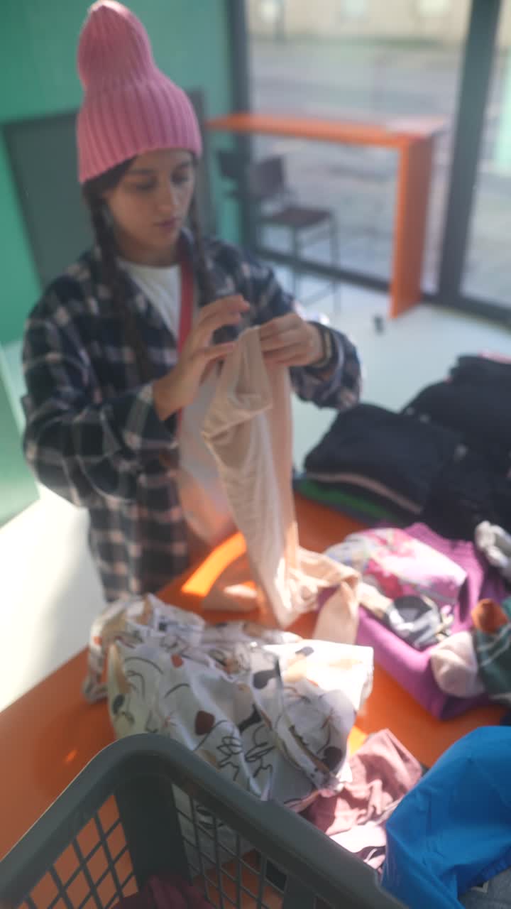 chica clasificando ropa en una lavandería
