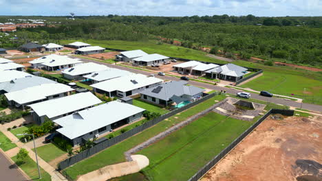 Drone-Aéreo-De-Construcción-De-Una-Nueva-Casa-Mientras-El-Automóvil-Pasa,-Territorio-Del-Norte-De-Zuccoli-Australia,-Establecimiento-De-Ubicación-De-Retroceso