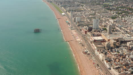 High-aerial-slider-shot-over-Old-brighton-pier-and-beach-towards-town-centre